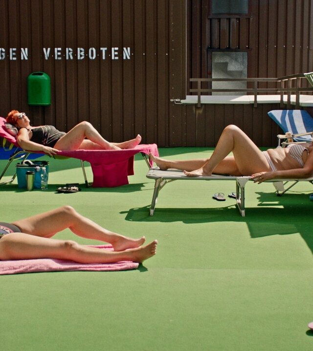 "27 Storeys": Auf einer Dachterasse liegen Menschen in Badebekleidung in der Sonne.