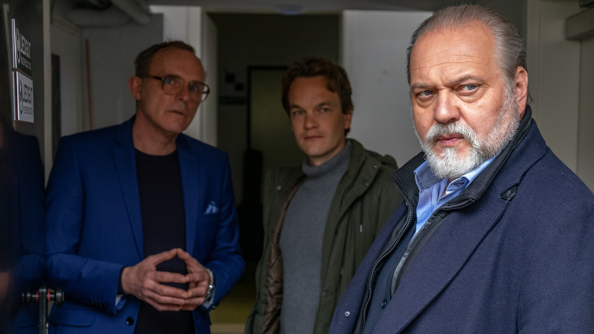 "Der Alte - Unsterblich": Dieter Behrens (Dirk Martens) steht im Hintergrund neben Tom Kupfer (Ludwig Blochberger), Hauptkommissar Voss (Jan-Gregor Kremp) steht im Vordergrund. Alle schauen in die gleiche Richtung.