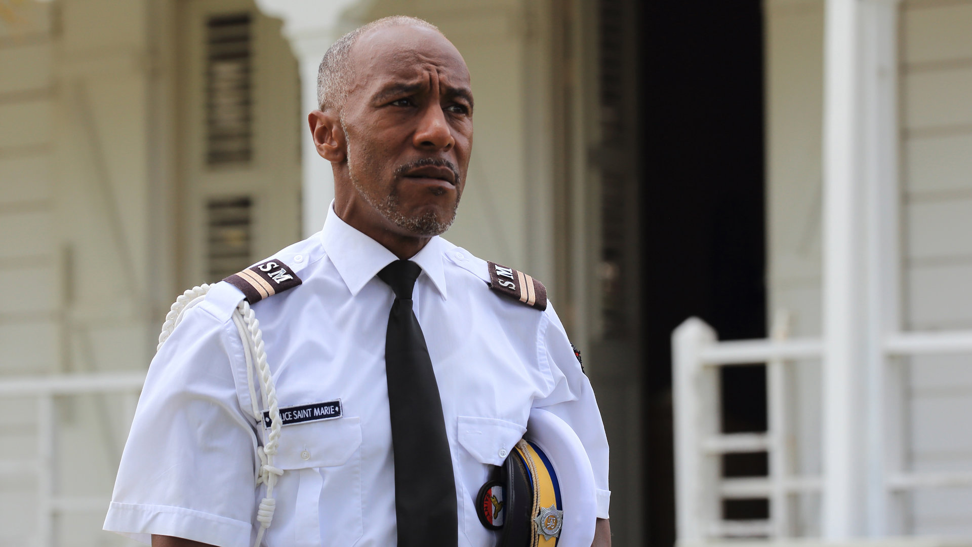 "Death in Paradise - Späte Reue": Dwayne Myers (Danny John-Jules) in Nahaufnahme. Er trägt eine Ausgehuniform.