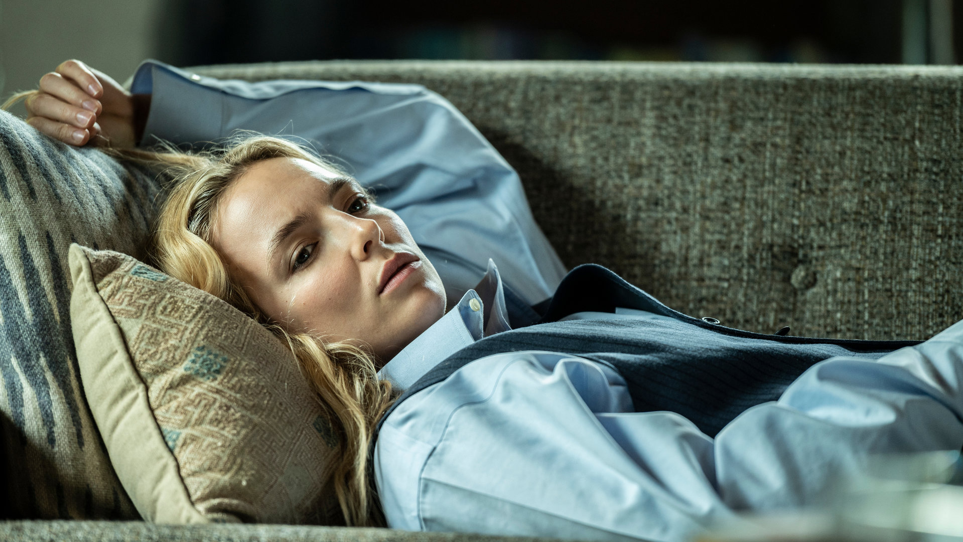 "Killing Eve - Ein Regenbogen in beigen Stiefeln": Villanelle (Jodie Comer) liegt auf einer Couch und schaut betrübt in die Ferne.