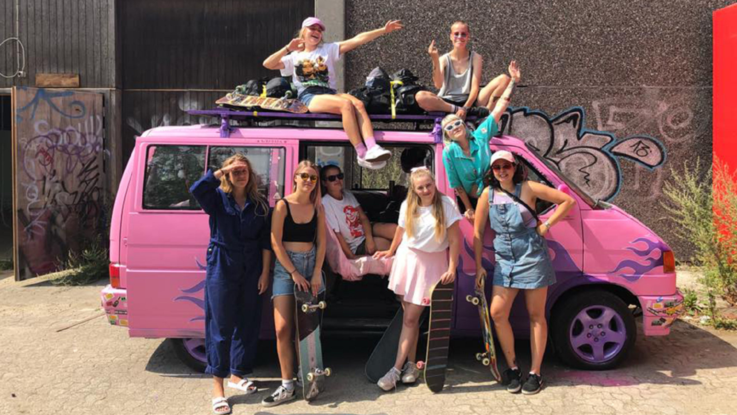 "Ab 18! - Skater Girls": Eine Gruppe junger Frauen steht vor einem rosa Bus.