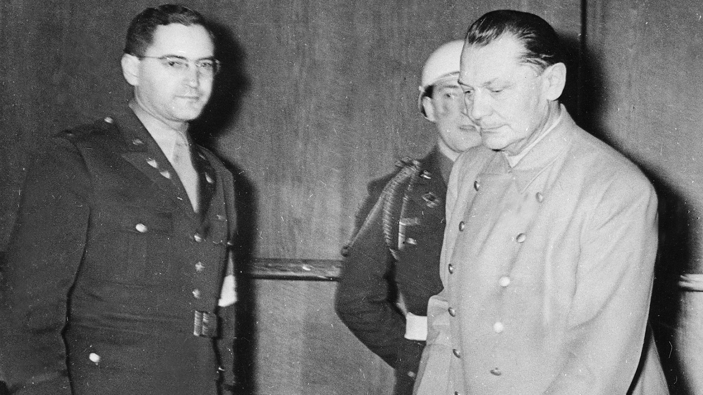 "ZDF-History: Hitlers Helfer auf der Couch - Der Psychologe von Nürnberg": Schwarz-Weiß-Aufnahme von drei Männern nach der Vernehmung Hermann Görings.