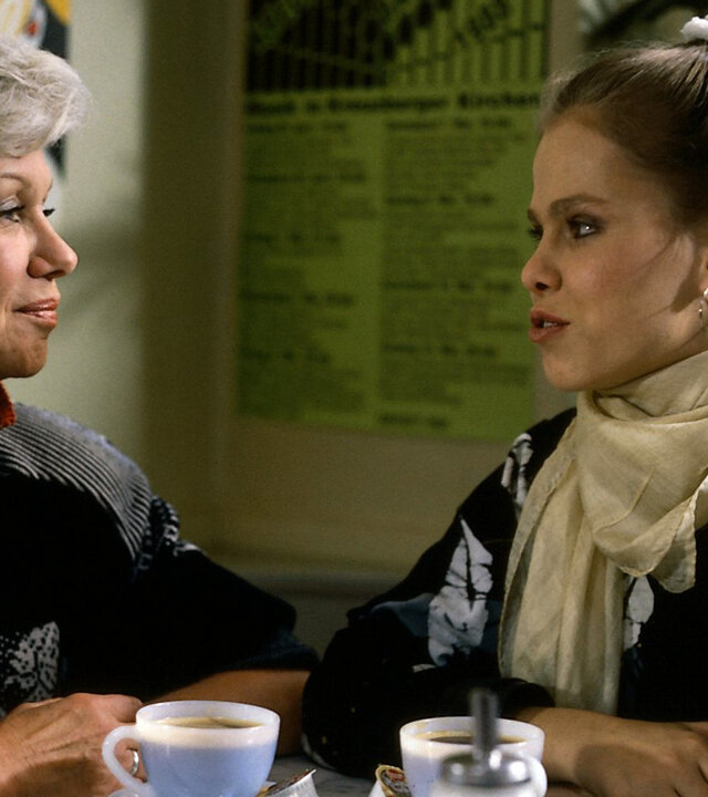 "Die Wicherts von nebenan: Ein tragischer Abschied": Hannelore (Maria Sebalt) und Elke (Juliane Rautenberg) sitzen am Tisch, trinken Kaffee und unterhalten sich.