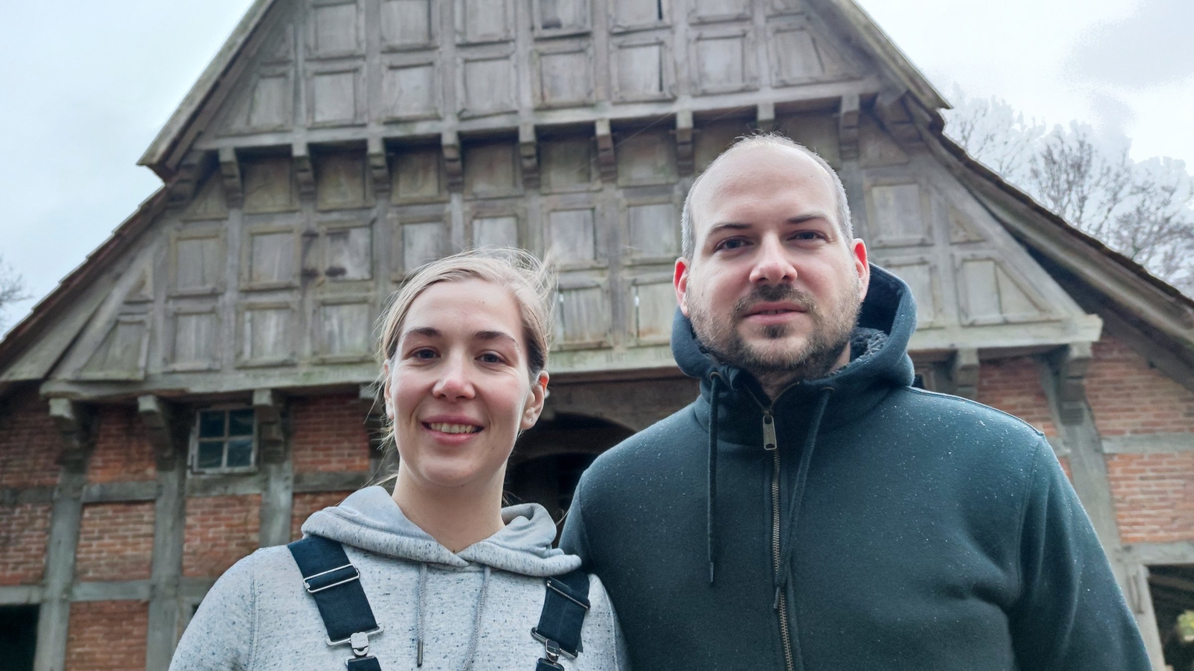 "Terra Xpress: Aufwachen, umdenken, anpacken: Hausbauen heute": Charlotte und Daniel stehen vor einem großen Backsteinhaus und lächeln in die Kamera.
