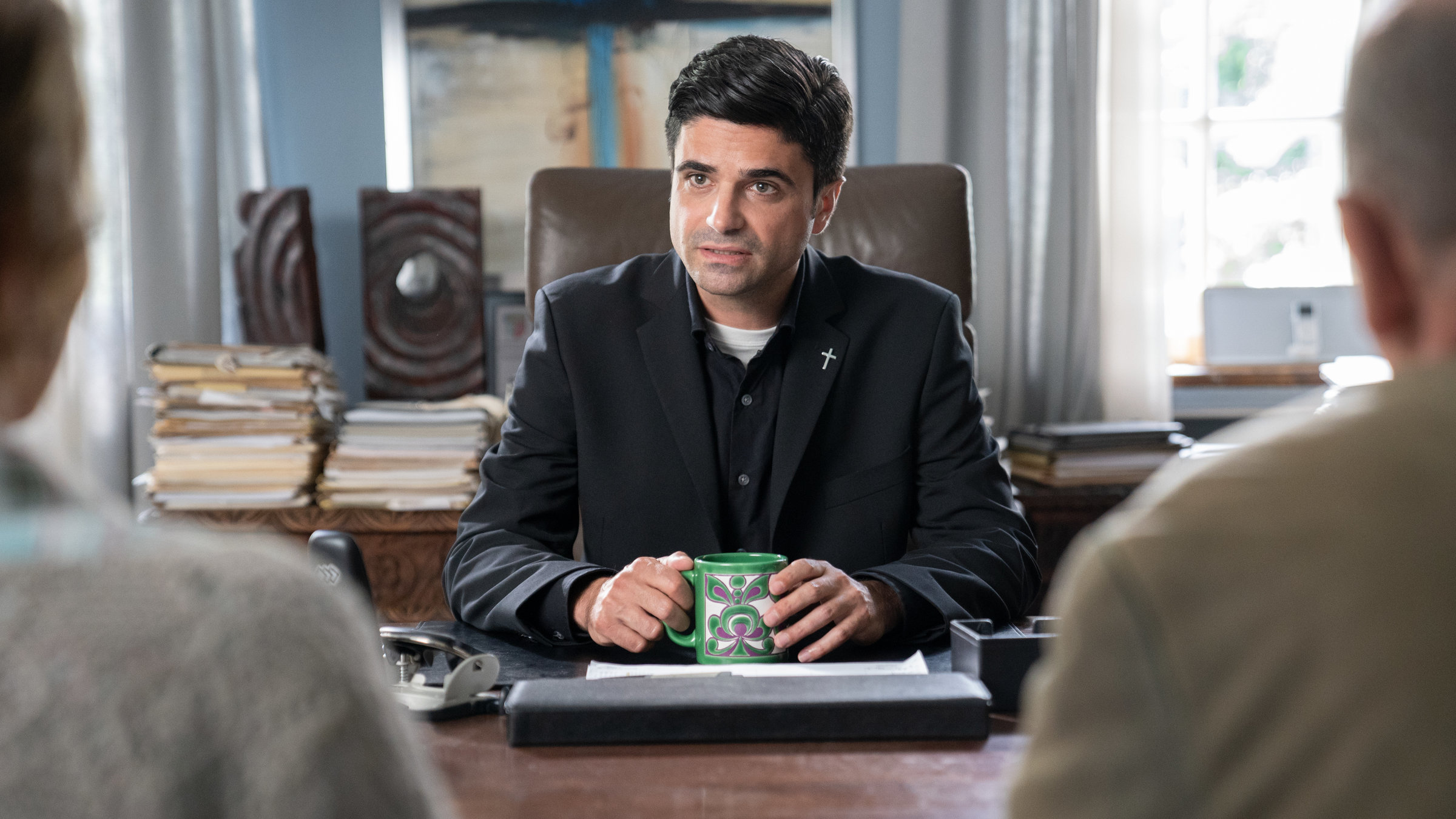 "Tonio & Julia - Wenn einer geht": An einem Tisch sitzt Tonio Niederegger (Maximilian Grill) und spricht zu einem Paar, das vor ihm sitzt.