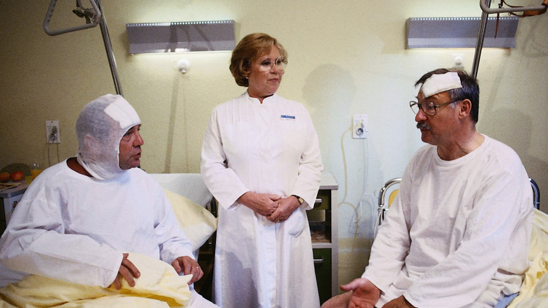 "Die Schwarzwaldklinik - Ein Kind, ein Kind, ein Kind": Kritz (Bruno Dallansky) und Dr. Basler (Rolf Schimpf) sitzen in ihren Krankenbetten und scheinen sich zu streiten. Oberschwester Hildegard (Eva Maria Bauer) steht schlichtend zwischen ihnen.