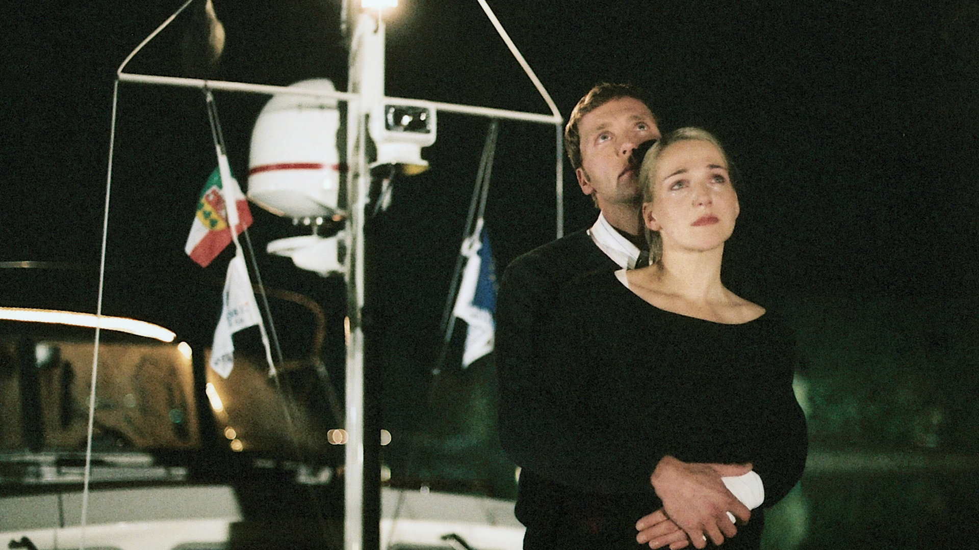 "Bianca - Wege zum Glück: Folge 53": Abends auf der Yacht: Oliver (Patrik Fichte) steht hinter Bianca (Tanja Wedhorn) und hält sie in seinen Armen. Beide schauen traurig nach oben. Bianca hat Tränen in den Augen.