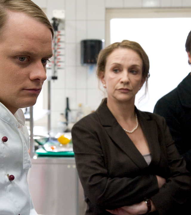 "SOKO Wismar - Tiefe Wunden": Moni Falkner (Cornelia Lippert) und Sven Herzog (Michael Härtle) stehen in einer großen Restaurant-Küche dem Koch Mark Schmidt (Stefan Konarske) gegenüber. Michael Härle trägt weiße Gummihandschuhe und Moni Falkner hat die Arme vor der Brust verschränkt.