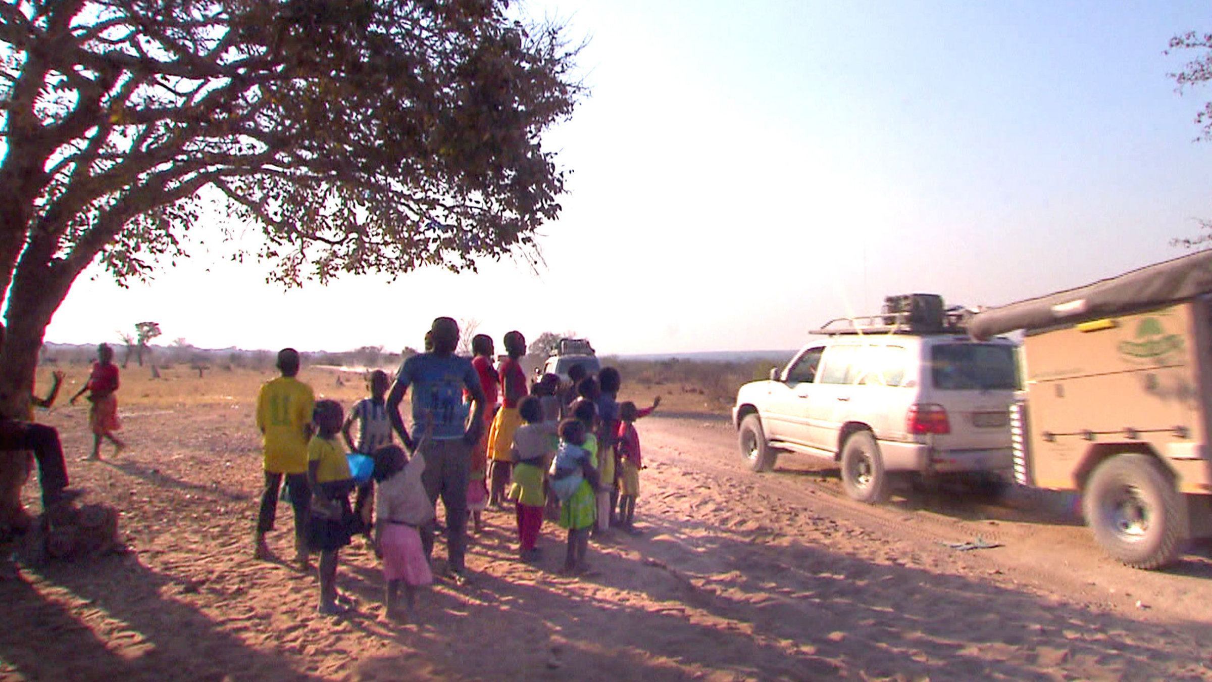 "Mit dem Jeep durch Angola" - Dorfbewohner von Angola und Jeep.