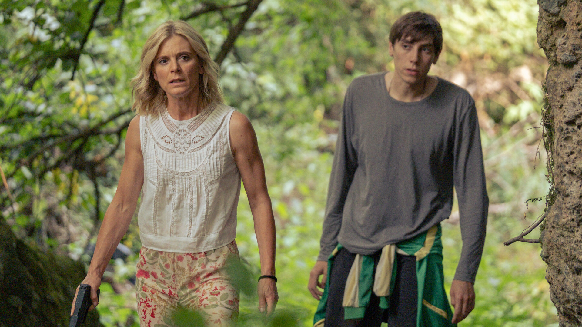 "Signora Volpe - Trug und Trüffel": Sylvia Fox (Emilia Fox) und Sasha Pavlenko (Alexander Arnold) gehen in einem Waldstück nebeneinander her. Sylvia hält eine Pistole in der rechten Hand.