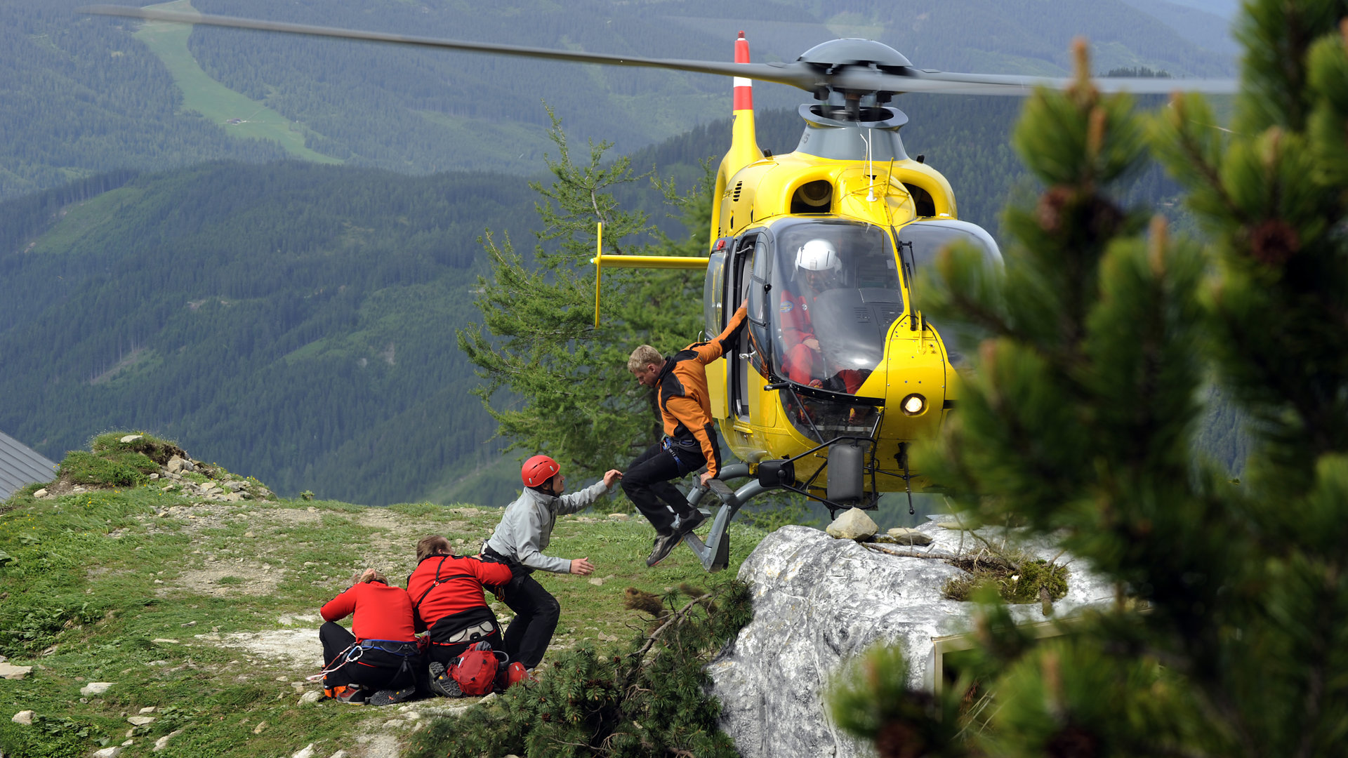 "Die Bergretter - Falsches Spiel": Andreas (Martin Gruber) springt aus dem schwebenden Heli auf ein Felsplateau. Dort sind weitere Kollegen der Bergrettung.