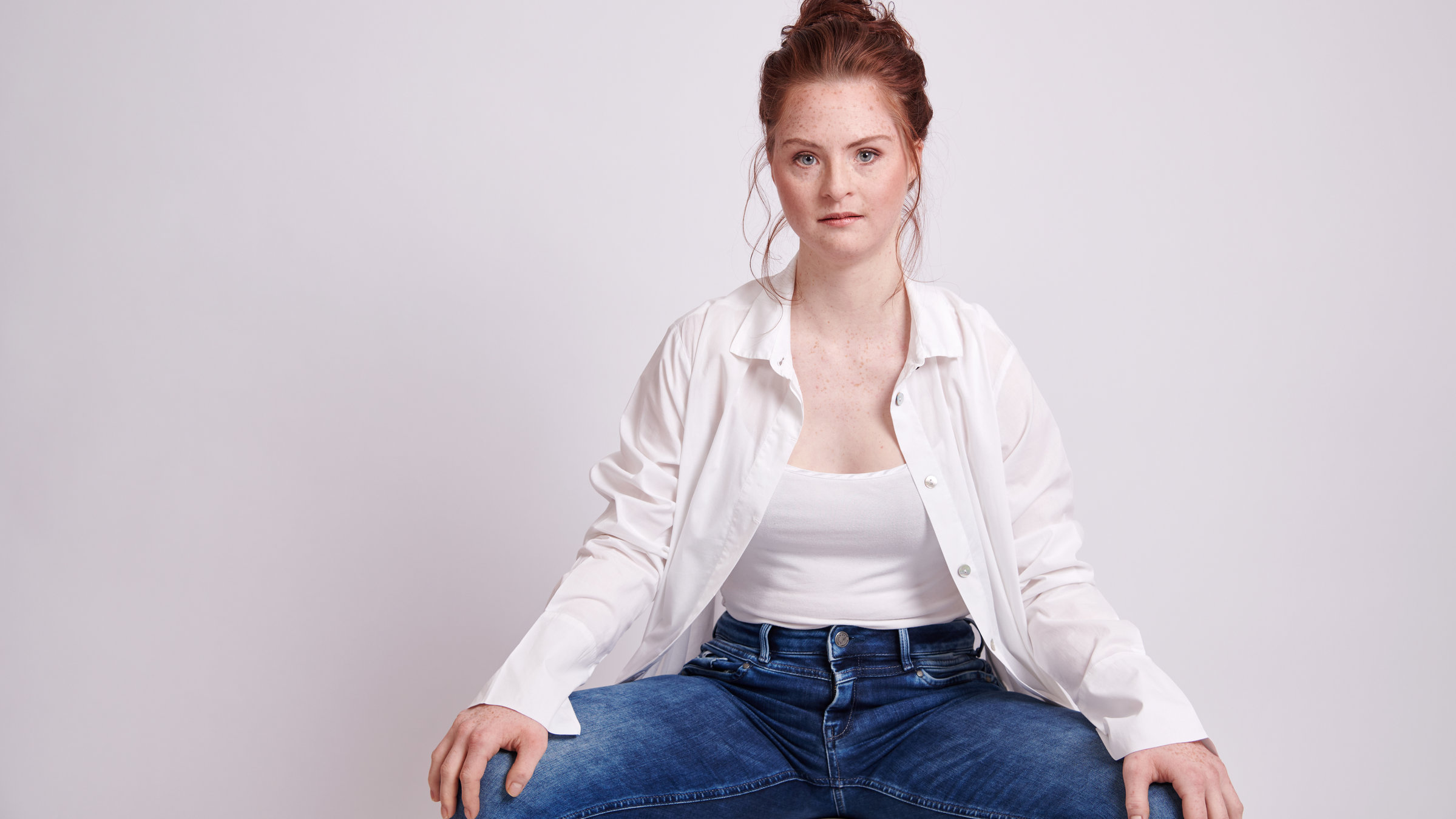 "Einfach Mensch! - „Das war mein Jahr!": Tamara Röske sitzt im Schneidersitz vor einer hellen Wand.