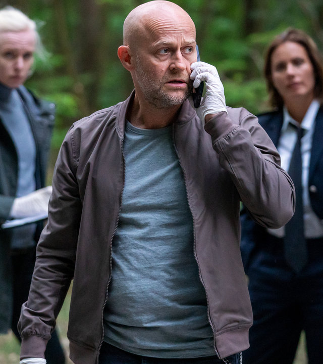 "Jenseits der Spree - Zwischen den Welten": Robert Heffler (Jürgen Vogel) telefoniert in einem Waldstück mit seinem Mobiltelefon. Katharina Koblinski (Elisabeth Baulitz) und Veronika Schäfer (Anne Müller) beobachten ihn aus dem Hintergrund.