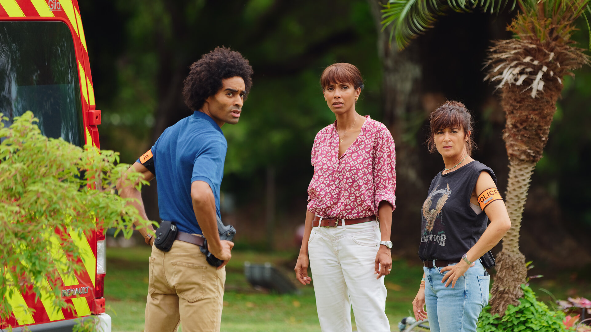 "Deadly Tropics - Mord aus Liebe": Aurélien (Julien Béramis), Mélissa (Sonia Rolland) und Gaëlle (Béatrice de la Boulave) stehen vor einem Krankenwagen und blicken besorgt in dieselbe Richtung.
