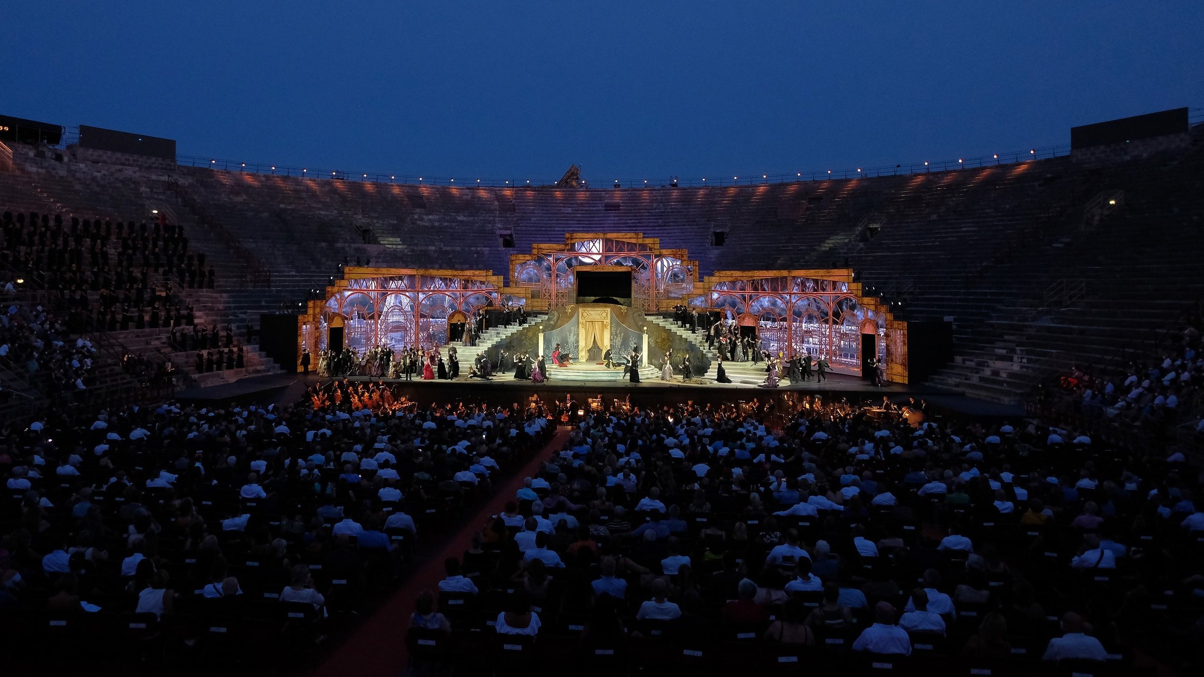 "Aus der Arena di Verona: Giuseppe Verdi - La Traviata": In der abendlichen Arena sitzt das Publikum vor einer imposanten Bühne.