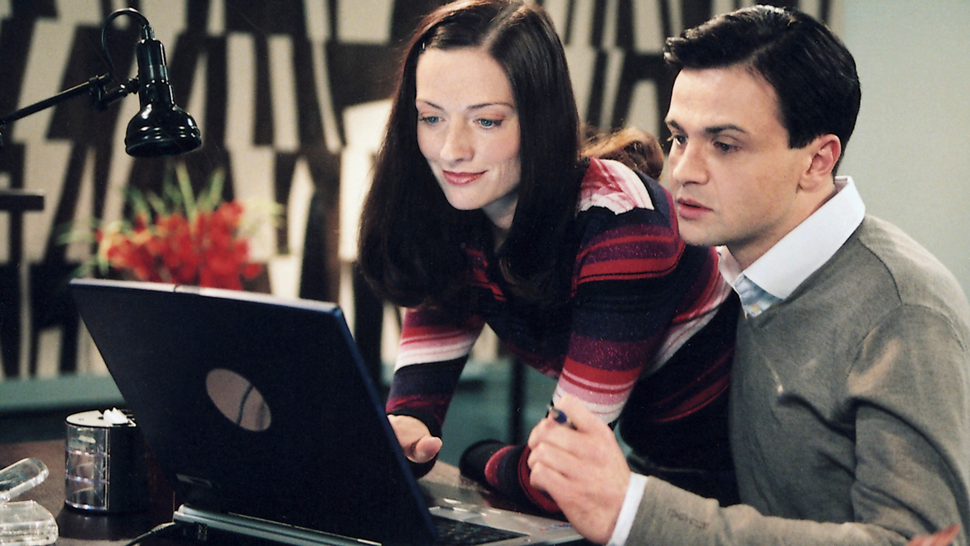 "Bianca - Wege zum Glück: Kapitel 135": An einem Schreibtisch: Pascal (Michael Rotschopf) und Katy (Nicola Ransom) schauen in einen geöffneten Laptop. Katy lächelt und Pascal wirkt angespannt.