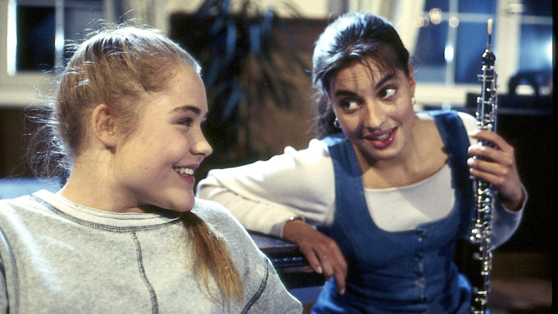 "Alle meine Töchter - Karrieresprünge": Patricia Sanwaldt (Floriane Eichhorn) und Sylvie von Wettenberg (Julia Dahmen) sitzen im Wohnzimmer nebeneinander und lächeln sich bedeutungsvoll an.