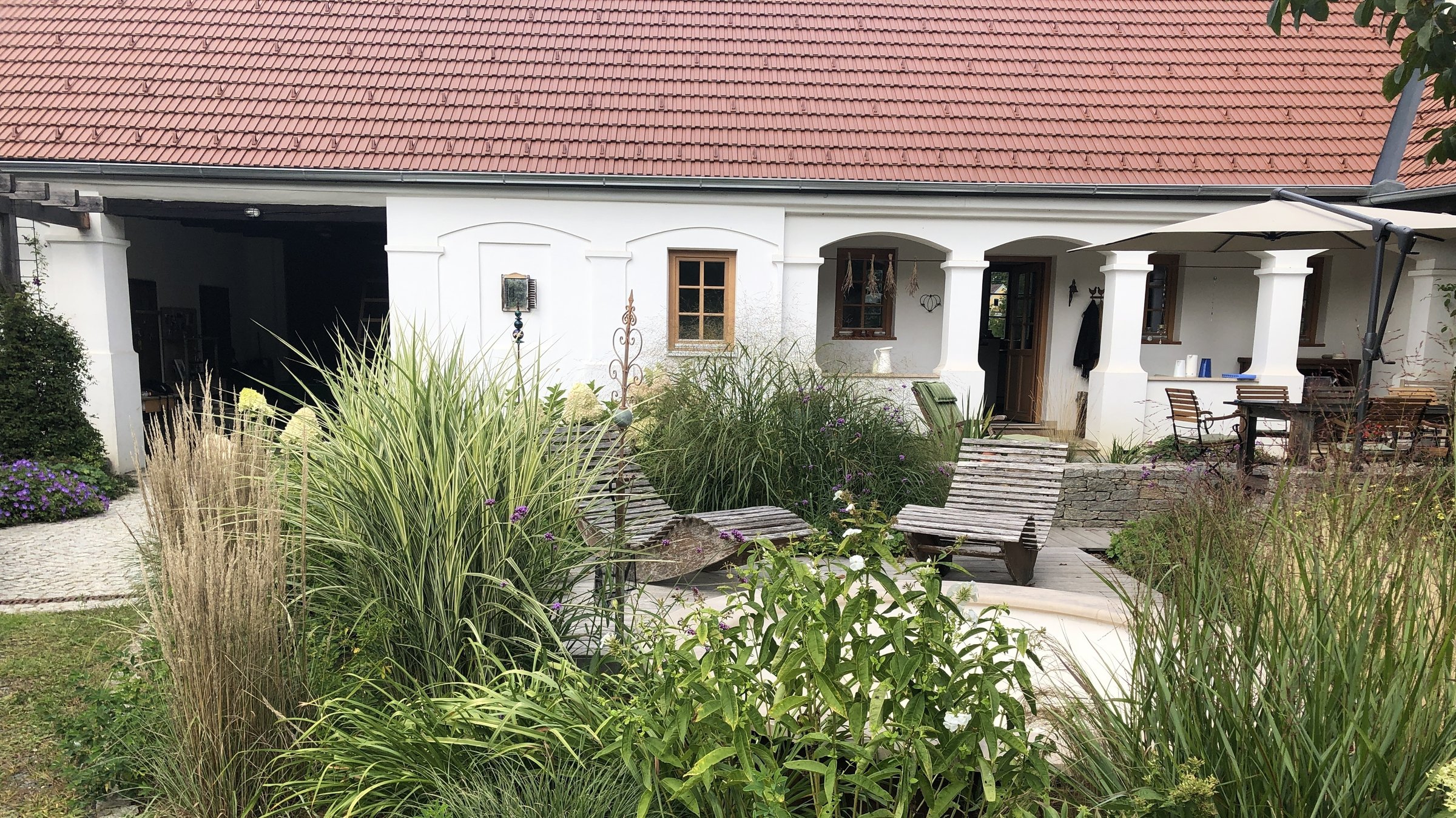 "Natur im Garten": Blick vom Garten über einen Freisitz zum Haus von Saskia Hula
