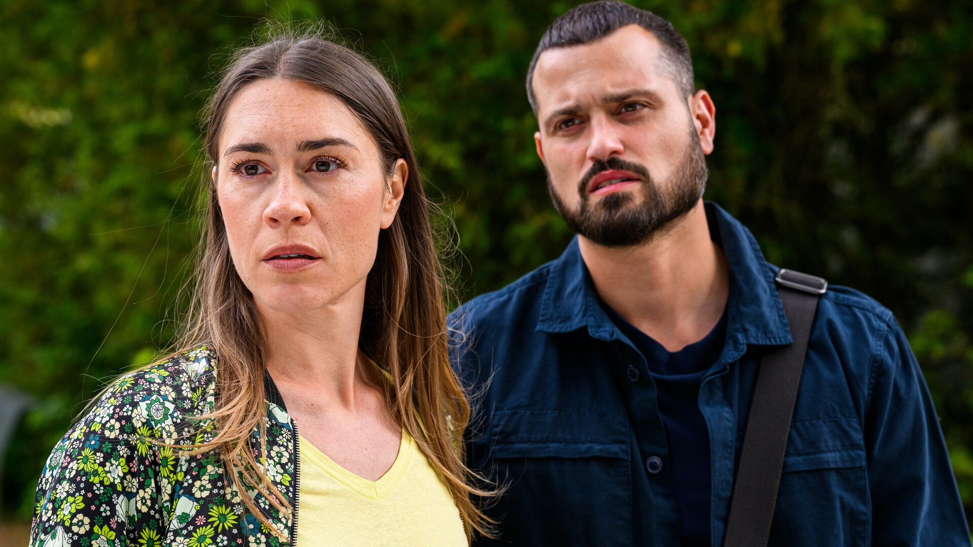 "Bettys Diagnose - Viva la Diva": Betty (Henrike Hahn) und Tarik (Nicolas Fethi Türksever) stehen nebeneinander vor einer hecke im Freien und schauen nach vorne.