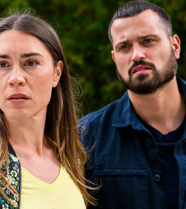 "Bettys Diagnose - Viva la Diva": Betty (Henrike Hahn) und Tarik (Nicolas Fethi Türksever) stehen nebeneinander vor einer hecke im Freien und schauen nach vorne.