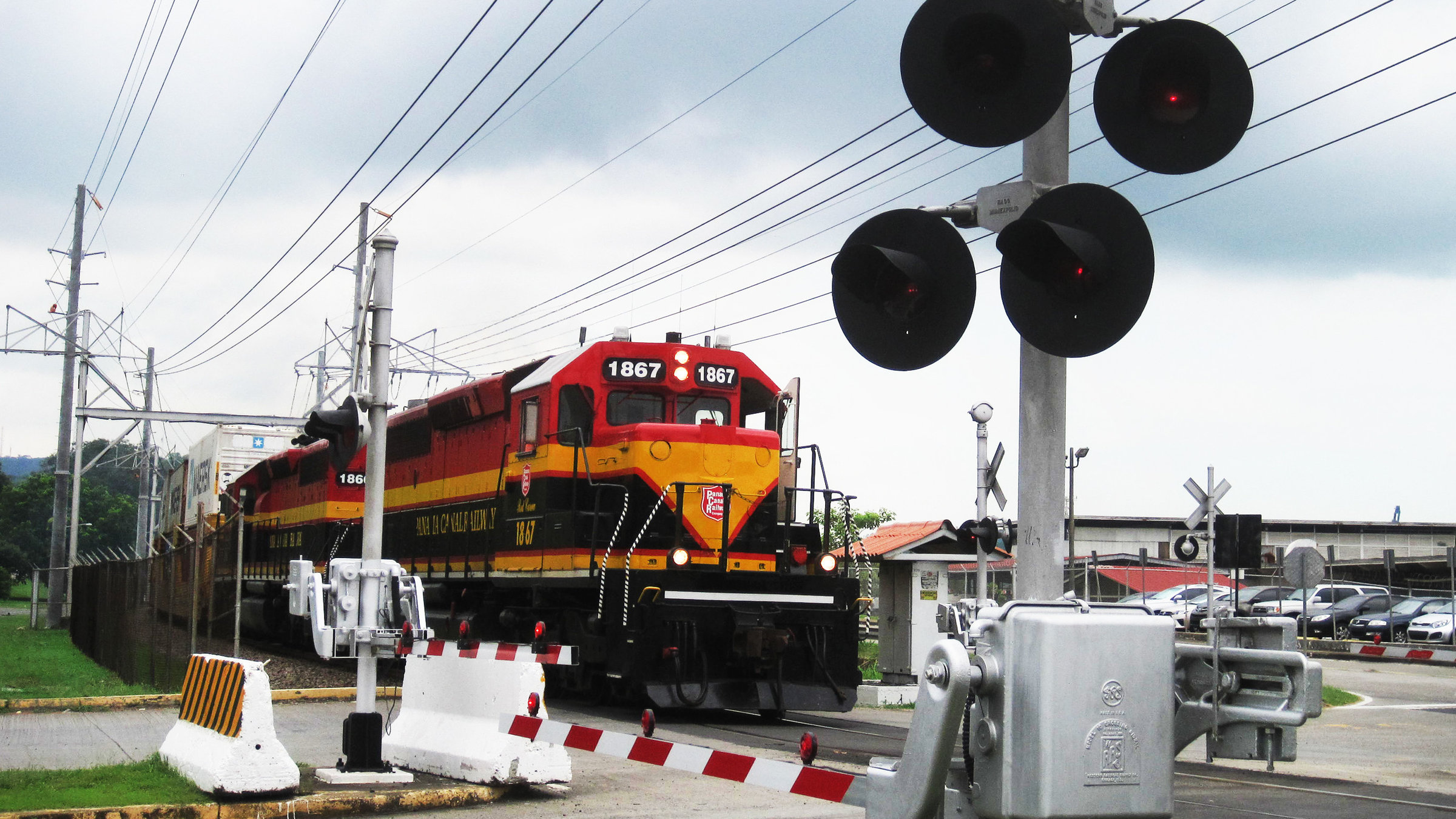 "Mit dem Zug durch Panama" - Zug an einem Bahnübergang.