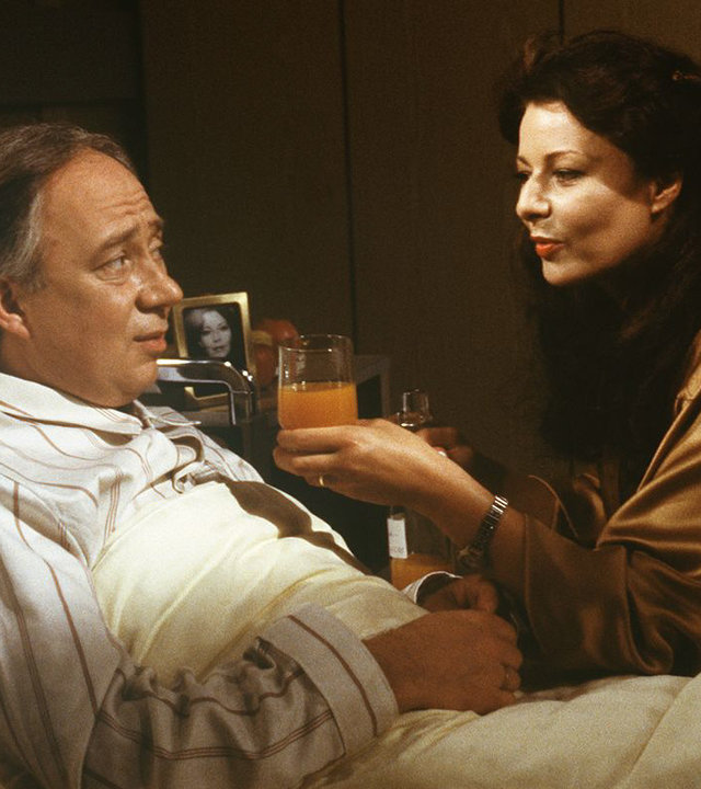 "Die Schwarzwaldklinik - Herzstillstand": Herr Schirner (Klaus Mikoleit) liegt im Krankenbett. Seine Frau (Garcia-Maria Kaus) reicht ihm ein Glas Saft.