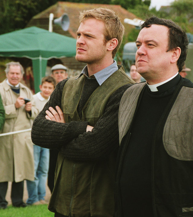 "Inspector Barnaby - Erst morden, dann heiraten": Reverend Anthony Gant (Richard McCabe) Roland Marwood (Joseph Kennedy) stehen auf dem Dorffest und schauen sich etwas an.