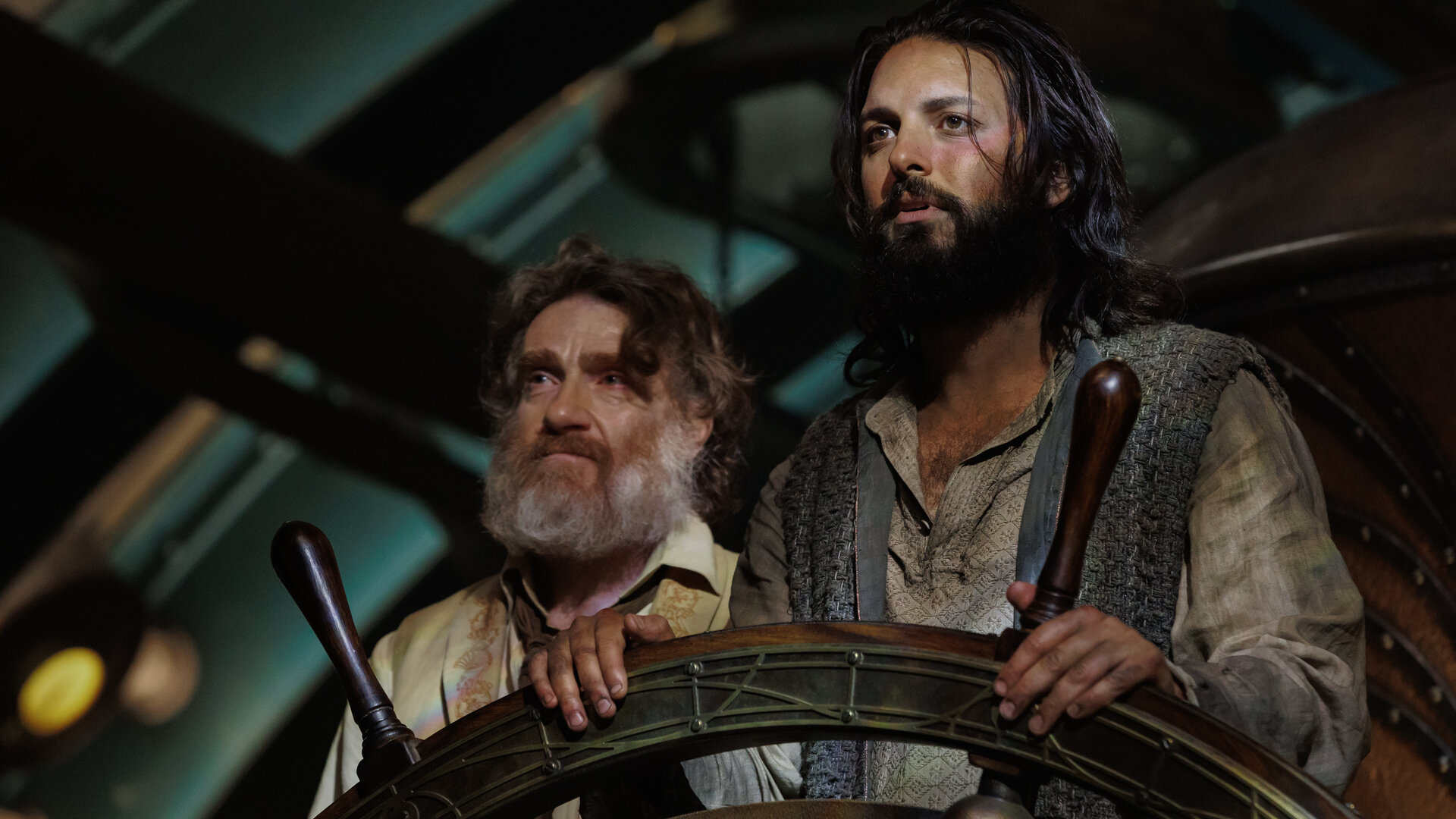 "Nautilus - Anahata": Nemo (Shazad Latif) und Benoit (Thierry Frémont) befinden sich in einem Raum. Nemo legt seine Hände auf ein Steuerrad, Benoit steht seitlich hinter ihm