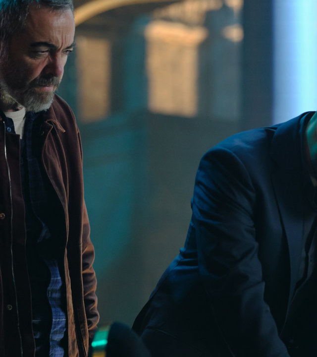 "Suspect - Folge 4: Jaisal": Jaisal (Sacha Dhawan) und Danny (James Nesbitt) stehen nebeneinander vor einem Schreibtisch und schauen sich die darauf liegenden Akten an.