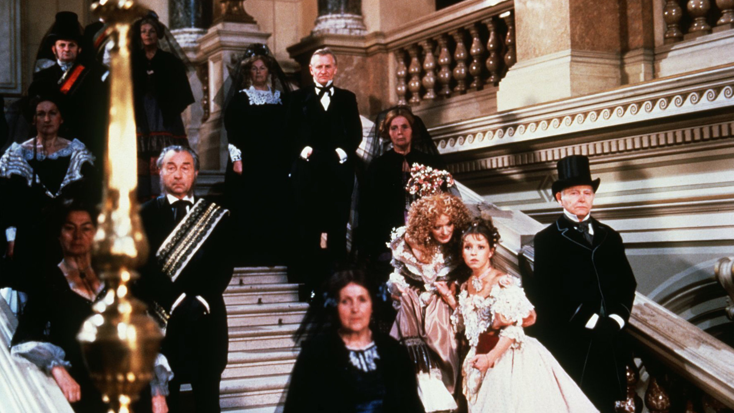 Die Glücksfee (Jana Brejchová) und ihr Lehrling Mina (Tereza Pokomá) treffen im Palast ein, in dem der Maskenball stattfindet.