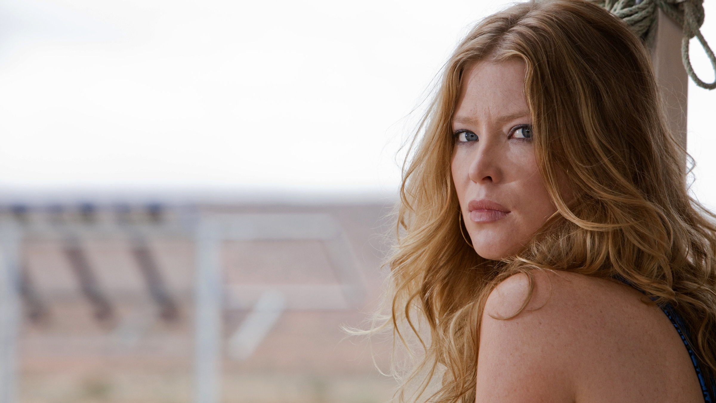 "Falscher Ort, falsche Zeit": Gina (Emma Booth) blickt ernst in die Kamera.