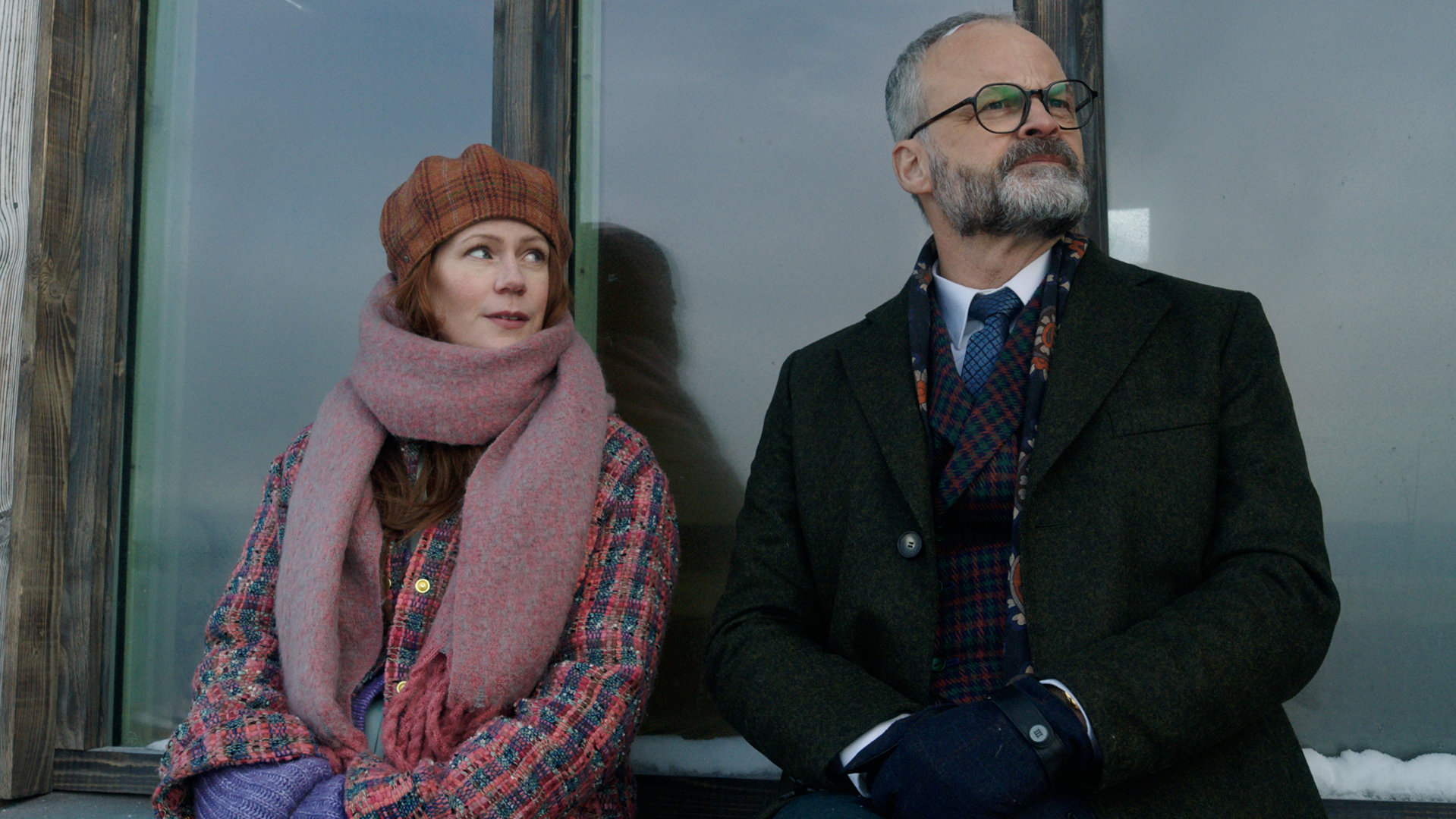 "Agatha Christies Hjerson (2)": Klara Sandberg (Hanna Alström) und Sven Hjerson (Johan Rheborg) sitzen nebeneinander auf einem vereisten Fenstersims.