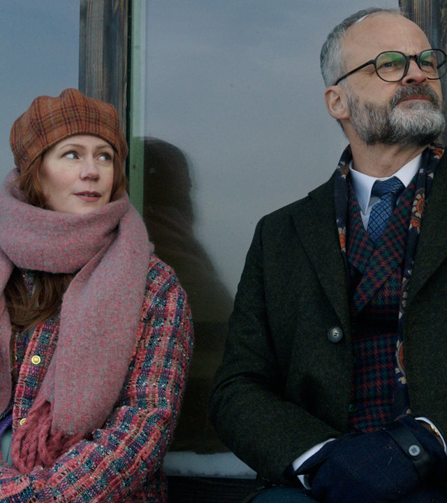 "Agatha Christies Hjerson (2)": Klara Sandberg (Hanna Alström) und Sven Hjerson (Johan Rheborg) sitzen nebeneinander auf einem vereisten Fenstersims.