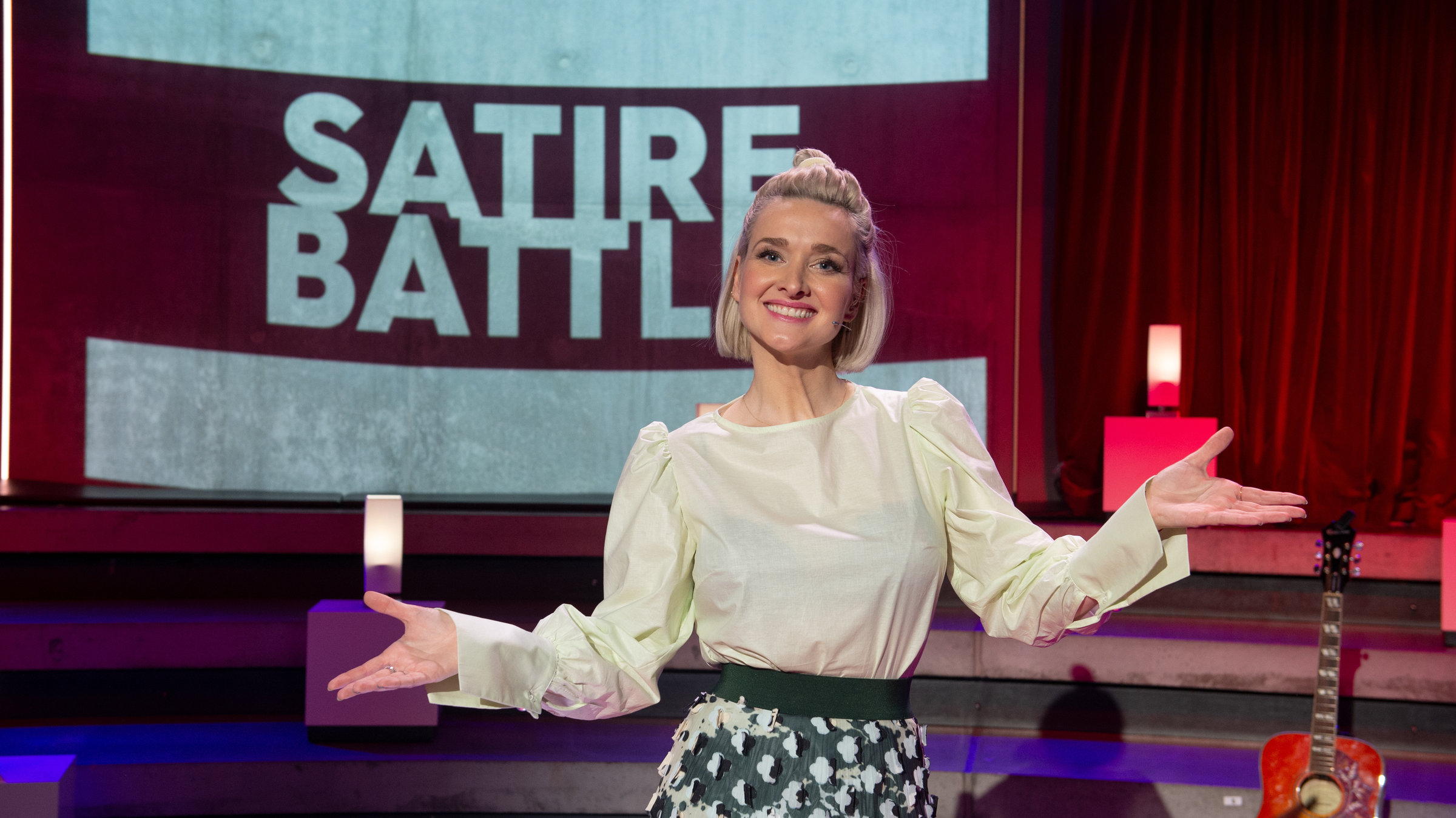 "Satire Battle": Ariane Alter steht vor der Bühne und posiert für die Kamera.