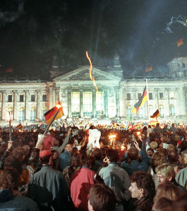 "Deutschland ''90 - Countdown zur Einheit": Menschenmassen vor dem Berliner Reichstag, die mit Feuerwerk, Deutschlandfahnen und Volksfesttrubel die wiedergewonnene Einheit Deutschlands feiern. Mit dem 3. Oktober 1990 sind die Deutschen 45 Jahre nach dem Ende des Zweiten Weltkrieges wieder in einem souveränen Staat vereint.
