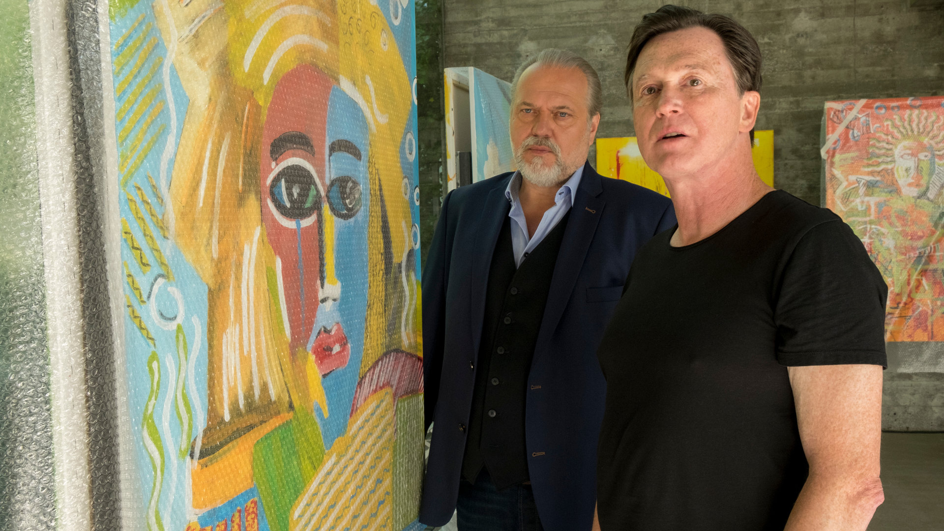 "Der Alte - Bild des Todes": Richard Voss (Jan-Gregor Kremp) und Ludwig Stern (Uwe Bohm) stehen nebeneinander in einer Galerie. Links neben ihnen steht ein großes buntes Gemälde. Im Hintergrund an den Wänden hängen weitere Bilder.