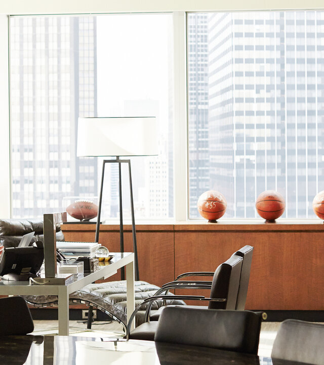 "Suits - Wissen, wann Schluss ist": Harvey (Gabriel Macht) sitzt an seinem Schreibtisch in einem hellen, modern eingerichteten Büro und blickt zu Mike (Patrick J. Adams), der mit ernster Miene im Raum steht. Im Hintergrund stehen mehrere Basketbälle auf einem Sideboard, dahinter ist die Skyline durch große Fenster zu sehen.