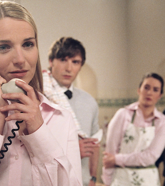 "Bianca - Wege zum Glück: Kapitel 99": In der Küche: Bianca (Tanja Wedhorn) telefoniert und wirkt dabei verständnisvoll. Im Hintergrund steht das Küchenteam (Christoph Mory, Nadja Robiné, Uwe Zerbe) und lauschen dem Telefonat.