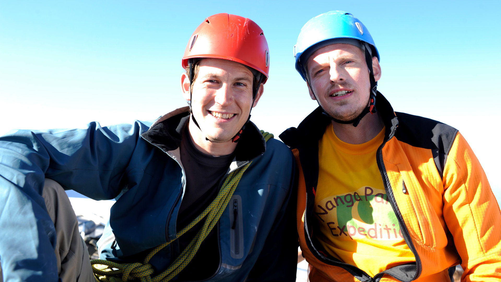 "Die Bergretter - Das Versprechen": Stefan (Stefan Murr) und Andreas (Martin Gruber) sitzen nebeneinander und lächeln in die Kamera.