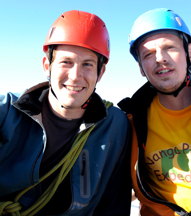 "Die Bergretter - Das Versprechen": Stefan (Stefan Murr) und Andreas (Martin Gruber) sitzen nebeneinander und lächeln in die Kamera.