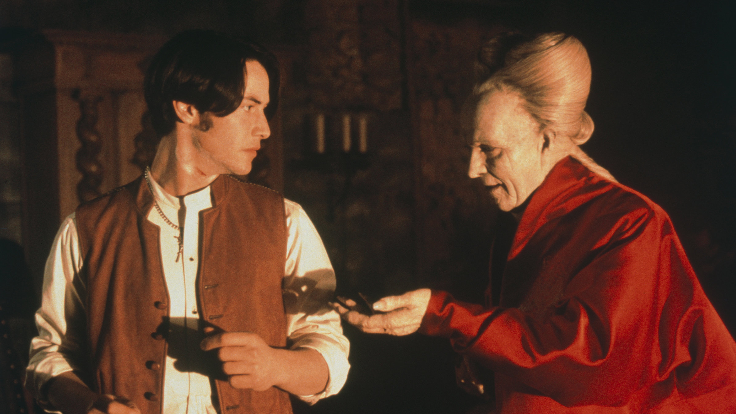 "Bram Stoker''s Dracula": Dracula (Gary Oldman) steht neben Jonathan Harker (Keanu Reeves) und streckt ihm die Hand entgegen, auf der ein Rasiermesser liegt. Harker schaut erstaunt über die Schulter zu Dracula.