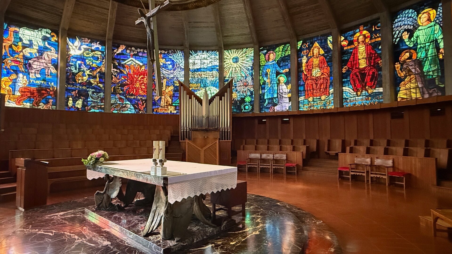 "Evangelischer Gottesdienst - Sonne und Salz": Im Altarraum der "Porciuncula, dem Gotteshaus des Franziskanerordens in Palma de Mallorca steht der Altar in der Mitte, rundherum sind farbenfrohe, prachtvoll gestalteten Glasfenster.