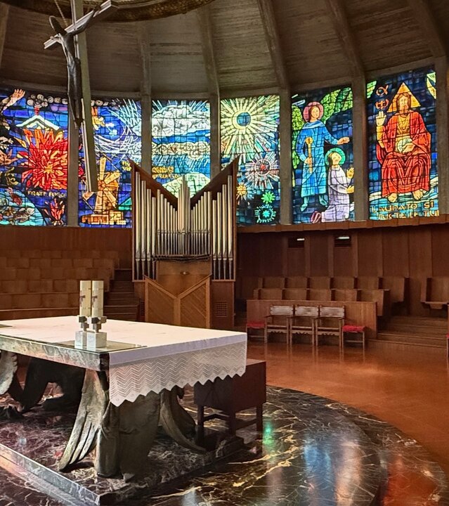 "Evangelischer Gottesdienst - Sonne und Salz": Im Altarraum der "Porciuncula, dem Gotteshaus des Franziskanerordens in Palma de Mallorca steht der Altar in der Mitte, rundherum sind farbenfrohe, prachtvoll gestalteten Glasfenster.