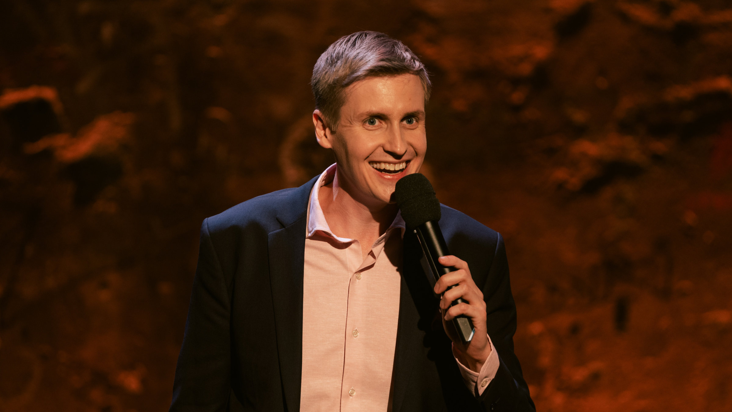 "Till Reiners` Happy Hour": der Moderator Till Reiners steht auf der Bühne und unterhält sein Publikum.