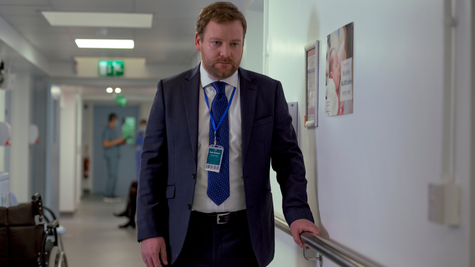 "Northern Lights - Neuanfänge": Lloyd (Stephen Jones) steht auf einem Flur im Krankenhaus und hält sich an einer Stange an der Wand fest. Er wirkt niedergeschlagen.