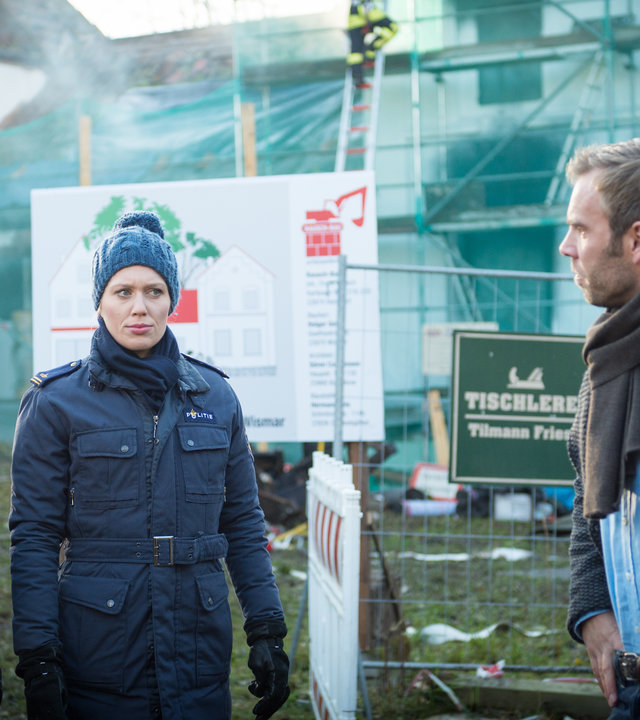 „SOKO Wismar – Tödlich frisch“: Katrin Börensen (Claudia Schmutzler), Lars Pöhlmann (Dominic Boeer), Anneke van der Meer (Isabel Berghout) und Timmermann (Mathias Junge) stehen nebeneinander. Im Hintergrund sind Einsatzwagen der Feuerwehr sowie die Brandstelle zu sehen.