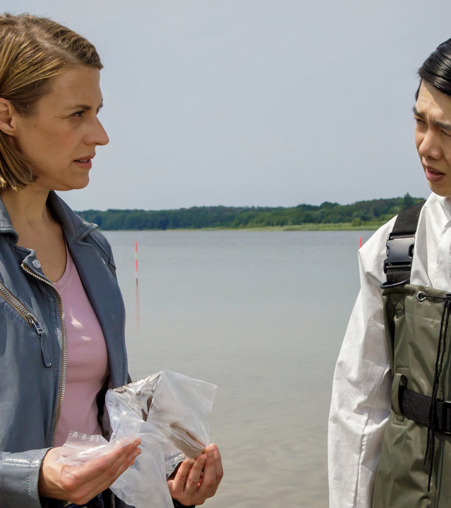 "SOKO Potsdam - Bauernopfer": Tamara Meurer (Anja Pahl) hält die vermutliche Tatwaffe in den Händen. Zusammen mit Thomas Brandner (Yung Ngo) steht sie nachdenklich an der Havel.