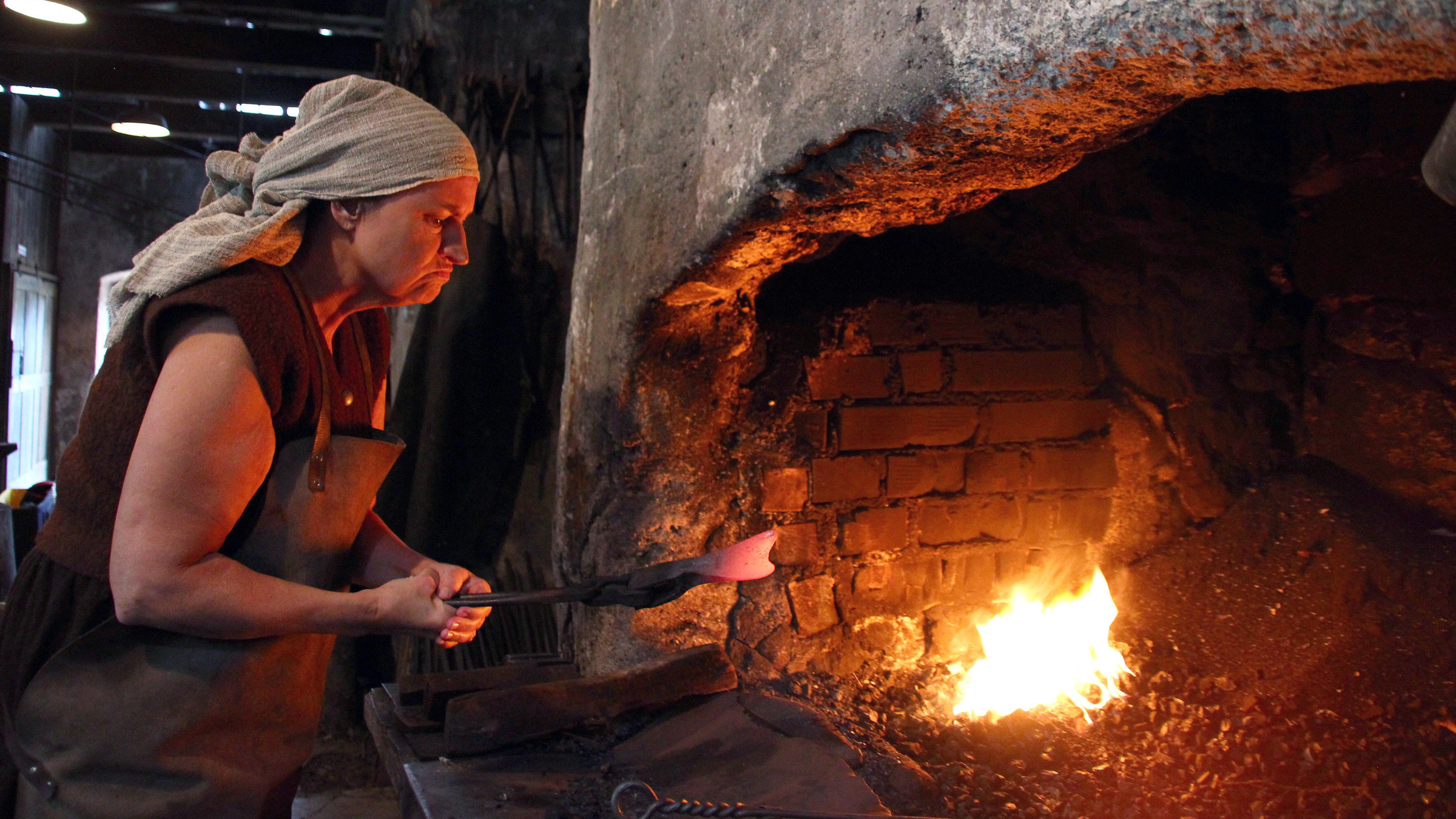 "Die Frauen der Eisenstraße": Frau beim Schmieden einer Hacke.