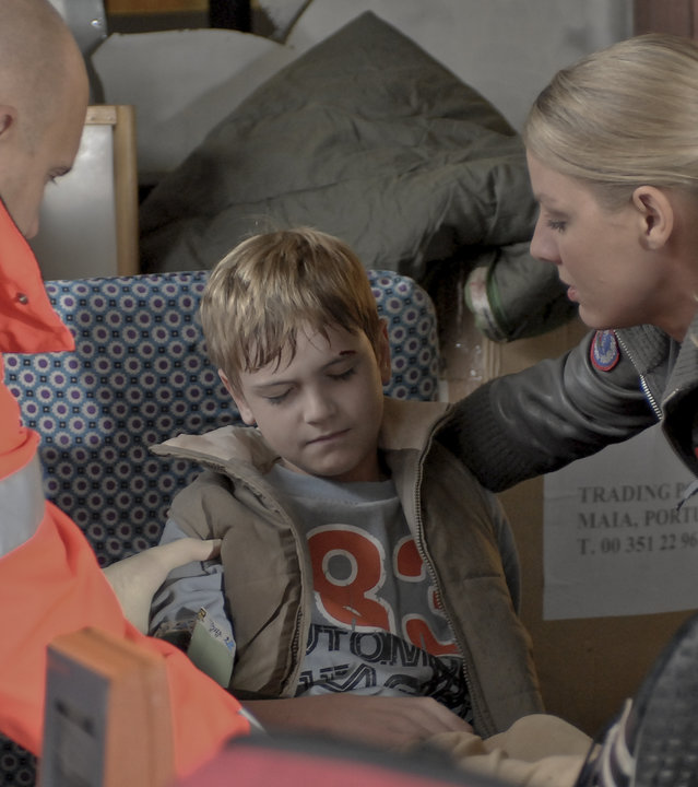 "Die Rettungsflieger - Klare Worte": Notärztin Dr. Sabine Petersen (Marlene Marlow) bückt sich zum verletzten Lukas (Maximilian Alber). Ein Rettungsassistent bückt sich ebenfalls zu dem Jungen hin.