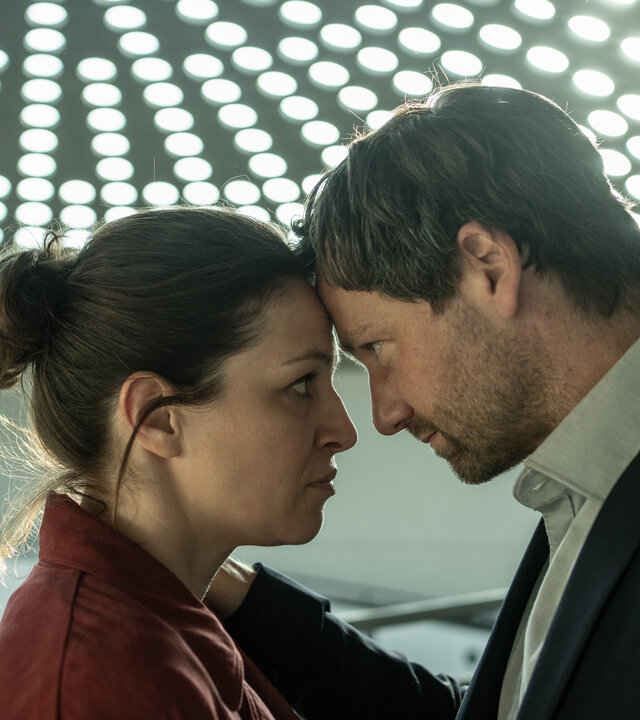 "Katharina Tempel - Was wir begehren": Katharina Tempel (Franziska Hartmann) und Volker Tempel (Florian Stetter) stehen sich Kopf an Kopf gegenüber und schauen sich an.